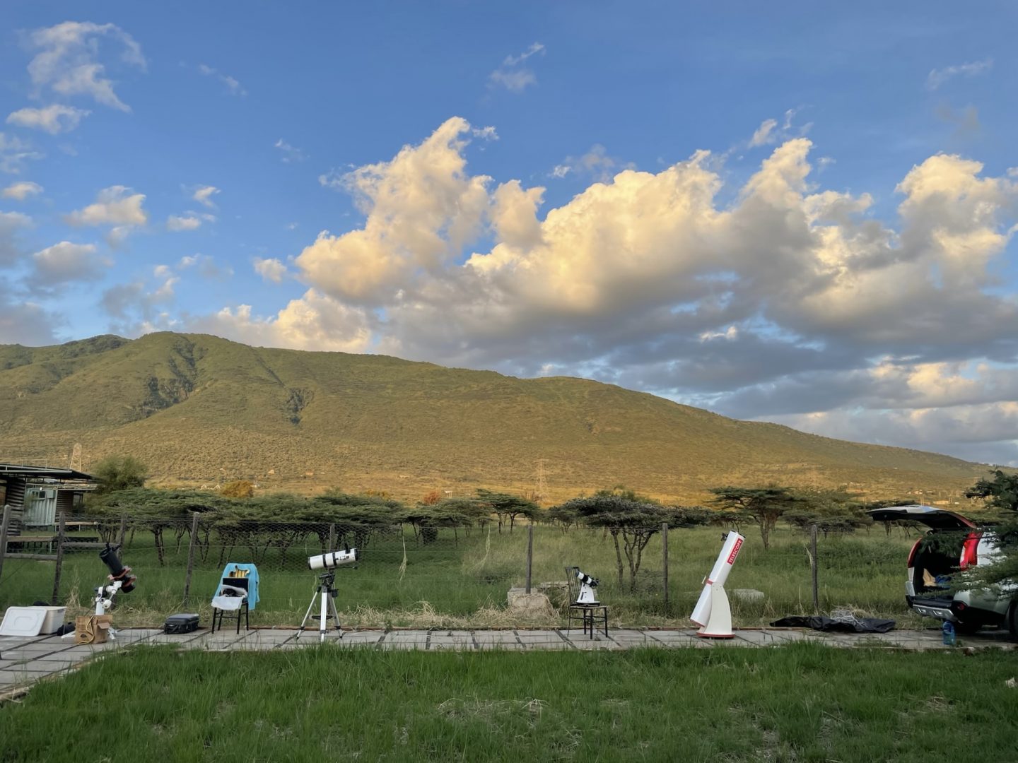 Telescopes set up in front of Ngong Hills, in the warm last light of the day.