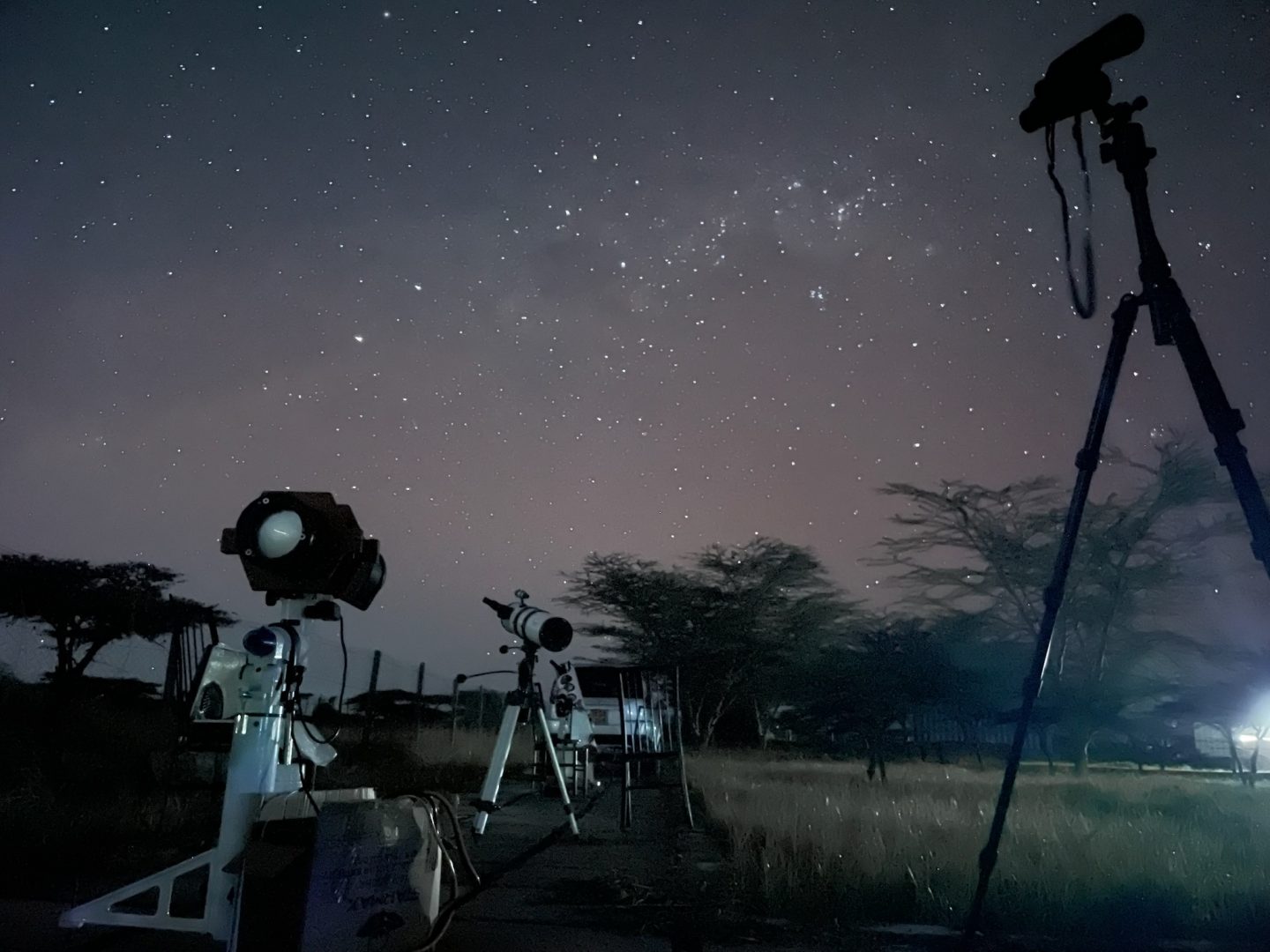 Telescopes and binoculars in front of the Southern night sky, with Carina, the Southern Cross and the Milky Way in the middle of it.